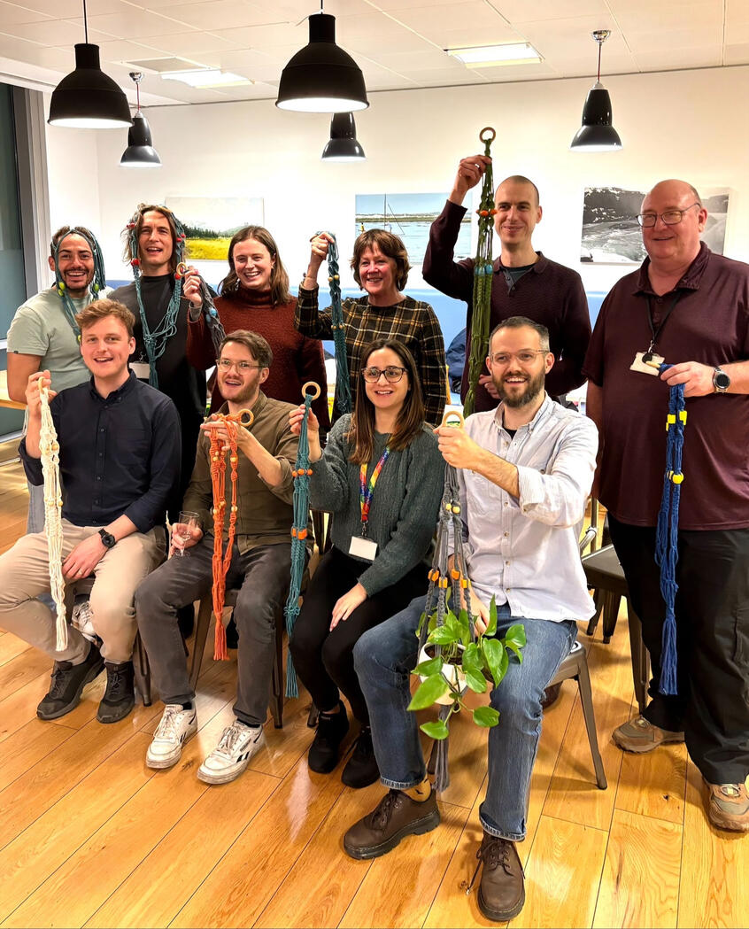 Successful, happy group of people after knotting their own macrame plant hanger